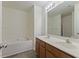 Bathroom with a double vanity, soaking tub, wood look floors and modern fixtures at 5940 Brambleton Ave, Raleigh, NC 27610