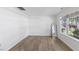 Bright bedroom with a large window, wood-look floors, and neutral wall color at 5940 Brambleton Ave, Raleigh, NC 27610