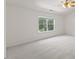Spacious bedroom with soft carpet, large window, and neutral tones throughout at 5940 Brambleton Ave, Raleigh, NC 27610