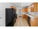 Kitchen featuring stainless steel appliances, laminate flooring, and wooden cabinets at 5940 Brambleton Ave, Raleigh, NC 27610