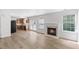 Living room featuring laminate flooring, fireplace, and open access to kitchen at 5940 Brambleton Ave, Raleigh, NC 27610