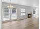 Bright living room featuring a fireplace, double doors, and new laminate flooring at 5940 Brambleton Ave, Raleigh, NC 27610