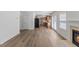 Open-concept living room with fireplace, laminate flooring, and view into kitchen area at 5940 Brambleton Ave, Raleigh, NC 27610