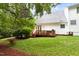 Beautiful home backyard with large, grassy lawn, wooden deck, and lush greenery at 601 Culpepper Ct, Durham, NC 27712