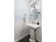 Charming powder room featuring a pedestal sink, decorative mirror, and wainscoting at 601 Culpepper Ct, Durham, NC 27712