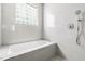 Bright and clean bathroom with a built-in bathtub, shower, and tiled walls at 601 Culpepper Ct, Durham, NC 27712