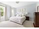 Bright bedroom featuring soft blue walls, plush carpeting, and a comfortable bed with decorative pillows at 601 Culpepper Ct, Durham, NC 27712