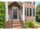 Close up of the brick front porch with a black door and traditional details at 601 Culpepper Ct, Durham, NC 27712