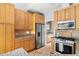 Kitchen with stainless steel refrigerator and appliances, natural wood cabinets, and granite counters at 601 Culpepper Ct, Durham, NC 27712