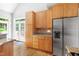 Kitchen featuring modern stainless steel appliances, granite countertops, and natural wood cabinets at 601 Culpepper Ct, Durham, NC 27712