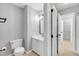 Bright bathroom featuring vanity with marble counter top, toilet, modern light fixture and doorframes at 6513 Hearthstone Dr, Raleigh, NC 27615