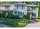 Charming townhome featuring a manicured lawn, flowering shrubs, and a lovely blue accent color at 6513 Hearthstone Dr, Raleigh, NC 27615