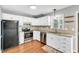 Updated kitchen features white cabinets, stainless steel appliances, and granite countertops at 6513 Hearthstone Dr, Raleigh, NC 27615