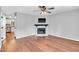 Bright living room featuring hardwood floors, a fireplace, and a modern ceiling fan at 6513 Hearthstone Dr, Raleigh, NC 27615