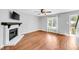 Comfortable living room with a fireplace, hardwood floors, and large windows for natural light at 6513 Hearthstone Dr, Raleigh, NC 27615