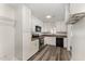 Well-lit kitchen featuring white cabinets, updated appliances, and wood-look vinyl flooring at 7315 Sandy Creek Dr # 7, Raleigh, NC 27615