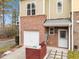 Back exterior of townhome with brick details, garage, outdoor patio and private entrance at 763 Blossom Grove Dr, Cary, NC 27519