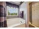 Relaxing main bathroom featuring a soaking tub, large window, and neutral color scheme at 8008 Bright Oak Trl, Raleigh, NC 27616