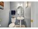 Stylish powder room with a pedestal sink, toilet, and light blue walls at 8008 Bright Oak Trl, Raleigh, NC 27616