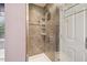 Tiled shower with a glass door and built-in shelving for toiletries at 8008 Bright Oak Trl, Raleigh, NC 27616