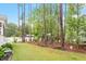 Serene backyard includes mature trees, lawn, and playhouse at 813 Whitley Way, Wendell, NC 27591