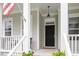 Inviting front porch featuring classic columns, black front door, and a charming welcome mat at 813 Whitley Way, Wendell, NC 27591