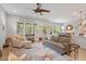 Open-concept living room with large windows, hardwood floors, comfortable seating, and views of the backyard at 813 Whitley Way, Wendell, NC 27591