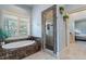 Bathroom with a soaking tub, glass shower, and tiled walls and floors at 8904 Milden Hall Ct, Raleigh, NC 27615