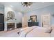 Spacious bedroom featuring a cozy fireplace, large windows, and elegant furnishings at 8904 Milden Hall Ct, Raleigh, NC 27615