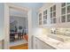 Well-appointed butler's pantry with mirrored tile backsplash, custom cabinetry and lighting at 8904 Milden Hall Ct, Raleigh, NC 27615