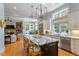 Open-concept kitchen with large island, modern lighting, and stainless steel appliances at 8904 Milden Hall Ct, Raleigh, NC 27615