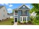 Charming blue two-story home featuring a bay window, landscaped front yard, and classic architectural details at 8925 Lee Brown Ridge Dr, Wake Forest, NC 27587
