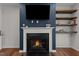 Fireplace with TV, built-in shelving, and hardwood floors at 8925 Lee Brown Ridge Dr, Wake Forest, NC 27587