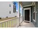 Inviting covered porch with white railings leads to a dark front door with welcome mat at 8925 Lee Brown Ridge Dr, Wake Forest, NC 27587