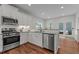 Modern kitchen with stainless appliances, white cabinets, and access to outdoor patio space at 8925 Lee Brown Ridge Dr, Wake Forest, NC 27587