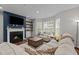 Cozy living room with fireplace, mounted TV, hardwood floors, and comfortable sectional sofa at 8925 Lee Brown Ridge Dr, Wake Forest, NC 27587