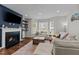 Inviting living room featuring a fireplace, mounted TV, hardwood floors, and comfortable sectional sofa at 8925 Lee Brown Ridge Dr, Wake Forest, NC 27587