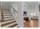 Open staircase featuring hardwood treads, white risers, and a view into the main living space at 8925 Lee Brown Ridge Dr, Wake Forest, NC 27587