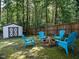 Backyard featuring a cozy firepit area with Adirondack chairs and a storage shed at 924 Magnolia Ridge Way, Fuquay Varina, NC 27526