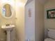 Cozy powder room with a pedestal sink, decorative mirror, and neutral wall colors at 924 Magnolia Ridge Way, Fuquay Varina, NC 27526