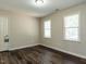 Bedroom features hardwood floors, two windows, and neutral paint at 924 Magnolia Ridge Way, Fuquay Varina, NC 27526