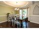 Elegant dining room featuring a modern chandelier, hardwood floors, and decorative windows at 924 Magnolia Ridge Way, Fuquay Varina, NC 27526
