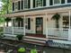 Inviting front porch with black door, hanging plants, and white railing at 924 Magnolia Ridge Way, Fuquay Varina, NC 27526