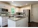 Bright kitchen featuring white cabinets, an island, granite countertops, stainless steel appliances, and hardwood floors at 924 Magnolia Ridge Way, Fuquay Varina, NC 27526