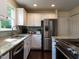Well-lit kitchen featuring white cabinets, granite countertops, stainless steel appliances, and wood flooring at 924 Magnolia Ridge Way, Fuquay Varina, NC 27526