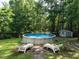 Large outdoor pool surrounded by lush trees and chairs at 924 Magnolia Ridge Way, Fuquay Varina, NC 27526