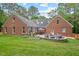 Brick home showcasing backyard with patio, firepit, and landscaped seating area at 9900 Two Robins Ct, Raleigh, NC 27613