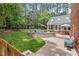 Serene backyard featuring a fire pit, brick patio, and ample seating amidst lush landscaping and mature trees at 9900 Two Robins Ct, Raleigh, NC 27613
