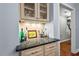 Bar area boasts granite countertops, cabinetry, and hardwood floors at 9900 Two Robins Ct, Raleigh, NC 27613
