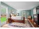 Well-lit bedroom with hardwood floors, area rug, and a sitting area near the windows at 9900 Two Robins Ct, Raleigh, NC 27613
